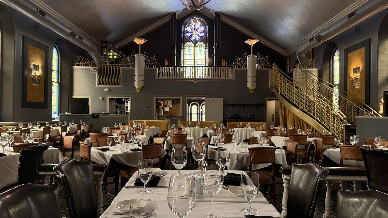 The dining room set for service beneath the rose window