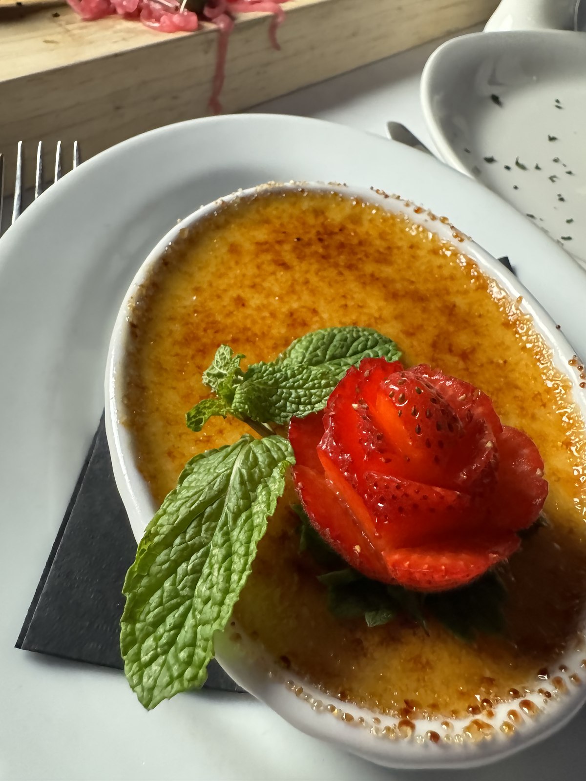 Cr&egrave;me br&ucirc;l&eacute;e with a strawberry rose and mint