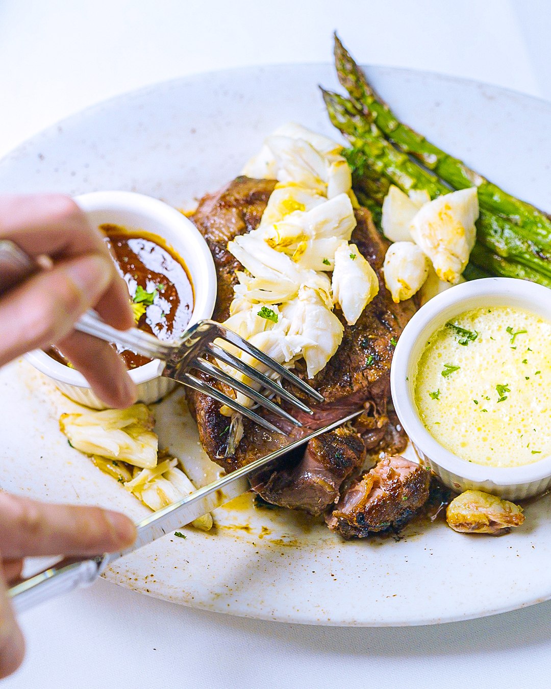 A Prime steak topped with lump crab meat, grilled asparagus and bearnaise sauce