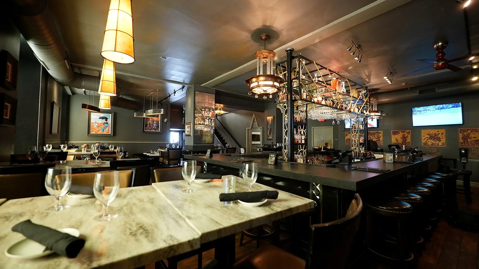The bar on the lounge level, with deco chandeliers above the marble tables